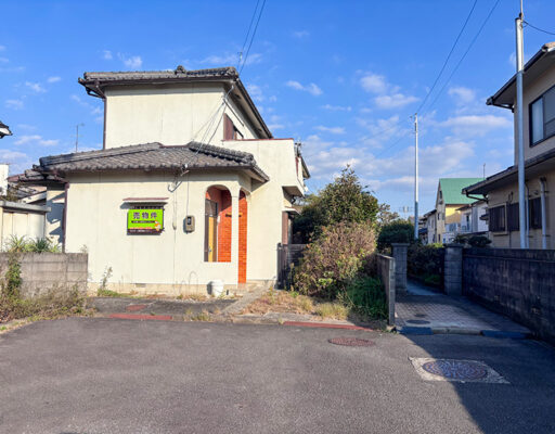 伊予市下吾川・新川駅徒歩4分の売土地。前面から古家と接道の様子がわかる写真