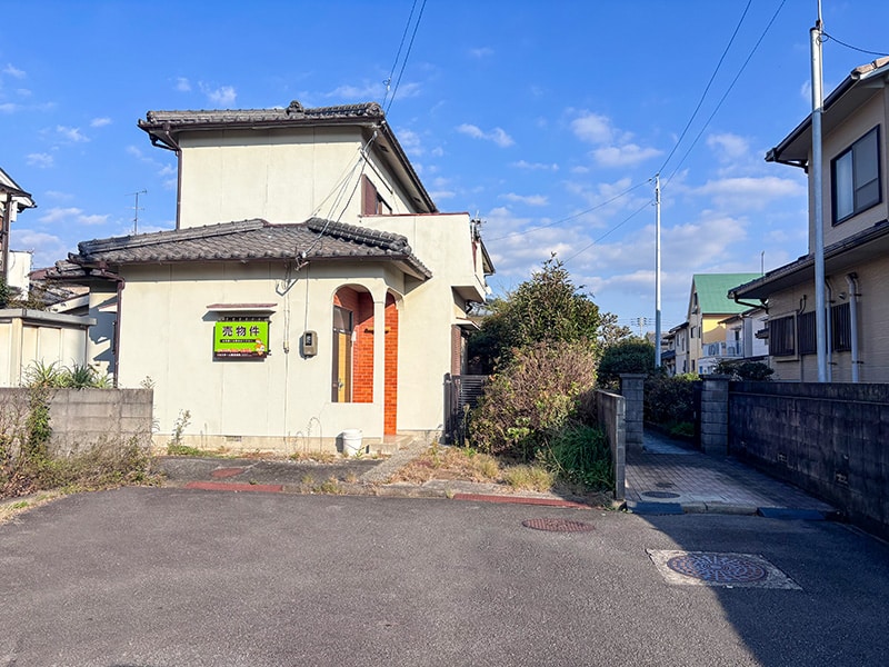 伊予市下吾川・新川駅徒歩4分の売土地。前面から古家と接道の様子がわかる写真