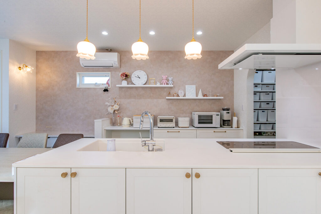 白で統一したキッチン。空間全体を見渡せる、安心感のある配置。