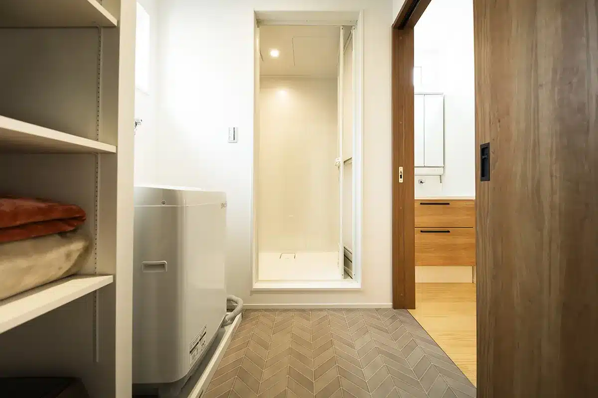 松山市K様邸・ヘリンボーン床のシャワー室・洗面脱衣室・ウォークインクローゼットが一体となった2階水回り動線