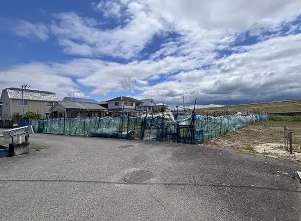 松山市西垣生町の売土地現地写真。約411.4坪の広々とした敷地と周辺環境が分かる全景