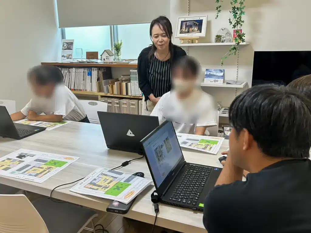 中学生3名がスタッフの説明を受けながら、住宅図面作成ソフトを操作している職場体験の様子